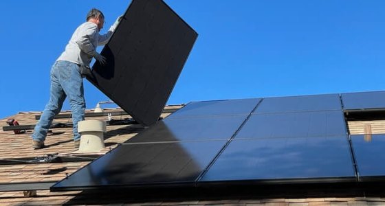 Man plaatst zonnepanelen op dak