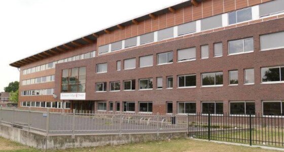 Afbeelding van schoolgebouw in Hengelo met hekken ervoor.