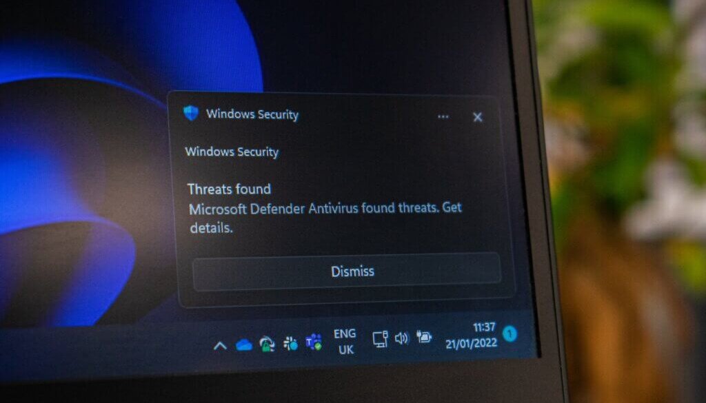 Laptop scherm met Windows antivirus melding in hoek.